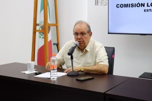Hombre sentado hablando frente a un micrófono