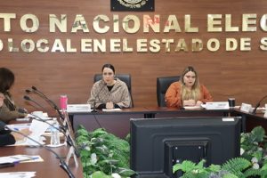 Dos mujeres sentadas en una mesa trabajando
