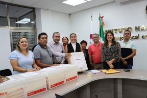 Personas mostrando cajas y sobres amarillos que contienen exámenes