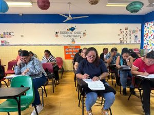 Salón de clases con varias personas haciendo un examen