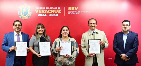 cinco personas de pie frente a un fondo rojo, mostrando un documento
