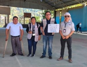 Cuatro trabajadores del INE están de pie en un deportivo