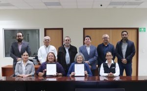 Asistentes al evento están de pie atrás de las titulares del INE y SEP Baja California Sur