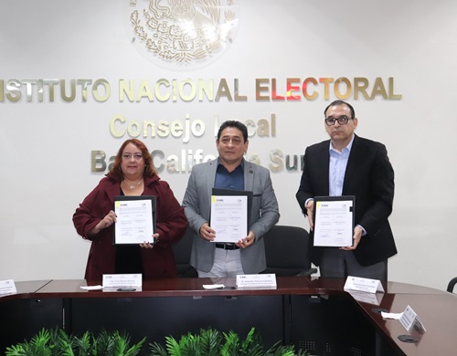 tras personas de pie mostrando el convenio firmado