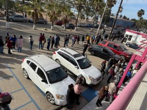 Personas haciendo fila afuera de un módulo de atención del INE