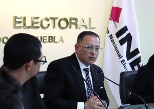 una persona sentada y hablando al micrófono