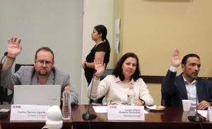 tres personas con la mano derecha alzada