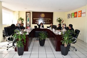 varias personas de consejo distrital sentadas en reunión de trabajo