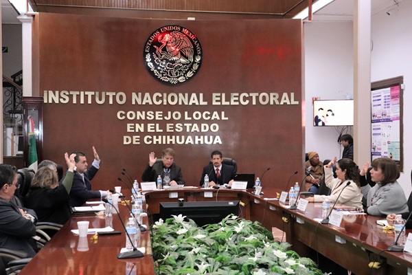 personas del consejo local votando con mano derecha alzada