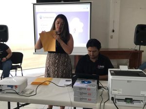 una persona de pie sosteniendo un sobre amarillo