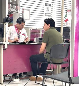 Persona masculina sentado enfrente del trabajador del INE Yucatán en un Módulo de Atención Ciudadana para tramitar su credencial para votar