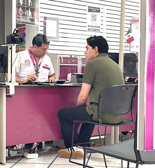 Persona masculina sentado enfrente del trabajador del INE Yucatán en un Módulo de Atención Ciudadana para tramitar su credencial para votar