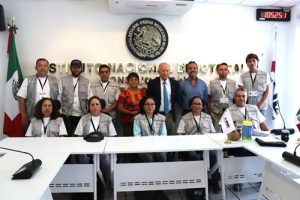 Supervisores electorales de pie y sentados posando para una foto