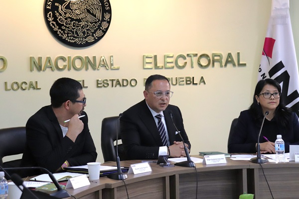 tres personas sentadas en reunión de trabajo