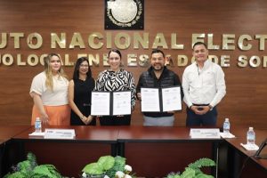 Vocal Ejecutiva del INE Sonora y titular del CEUNO están de pie mostrando la firma de convenio