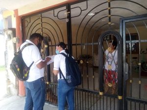 Dos trabajadores del INE Tabasco platicando con una señora en su afuera de su domicilio