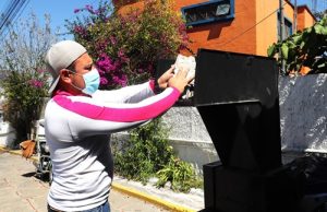 Trabajador del INE en Tlaxcala poniendo credenciales de elector no vigentes en una trituradora para su destrucción