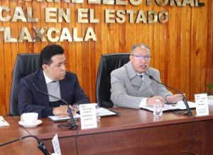 dos personas sentadas en una mesa durante sesión de trabajo