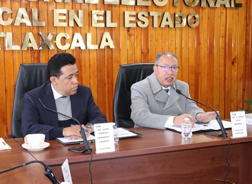 dos personas sentadas en una mesa durante sesión de trabajo