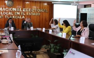 Consejeros y Consejeras del INE en Tlaxcala votando, alzando la mano derecha, los puntos del orden del día