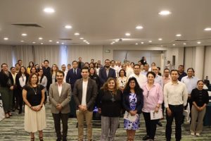 varias personas de pie en un salón, posando para la fotografía