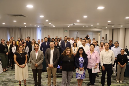 varias personas de pie en un salón, posando para la fotografía