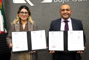 una mujer y un hombre mostrando un convenio de colaboración en Baja California