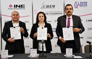 una mujer y dos hombres de pie, sosteniendo un documento