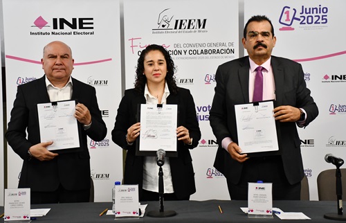 una mujer y dos hombres de pie, sosteniendo un documento