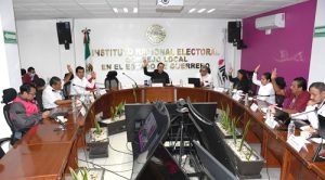 Varias personas votando a mano alzada en el Consejo Local del INE en Guerrero