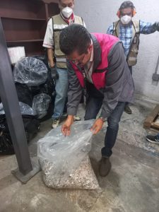Un hombre sosteniendo una bolsa que contienen credenciales