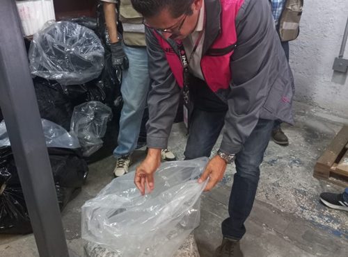 Un hombre sosteniendo una bolsa que contienen credenciales