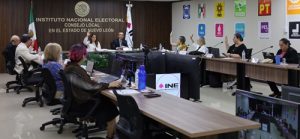 integrantes de consejo local sentados y votando a mano alzada