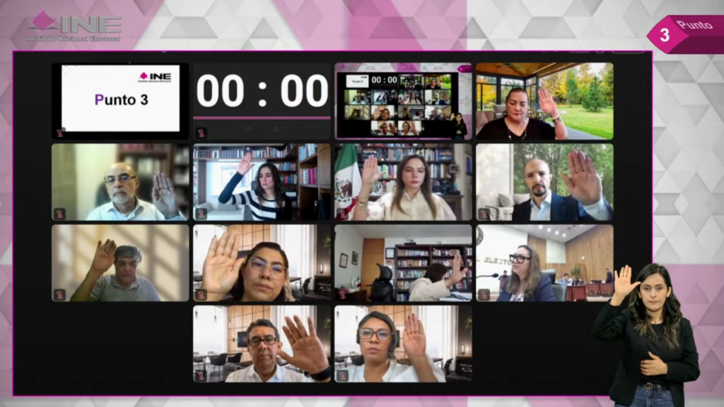 Sesión virtual del Consejo General, consejeras y consejeros alzando la mano por videollamada