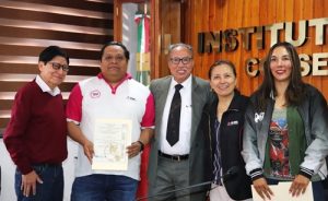 tres hombres y dos mujeres mostrando el certificado de calidad
