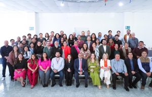 varias personas de pie y juntas para tomarse una foto