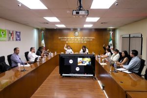 Integrantes del consejo local votando a mano alzada en sesión de trabajo