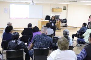 varias personas sentadas poniendo atención a otra persona que les habla