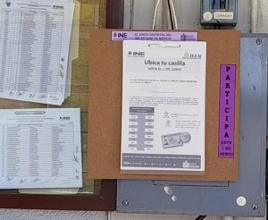 se muestra una lista de mesas directivas de casilla colgadas de una pared