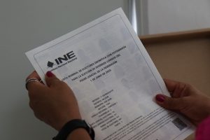 se muestra un documento de lista nominal sostenido en dos manos