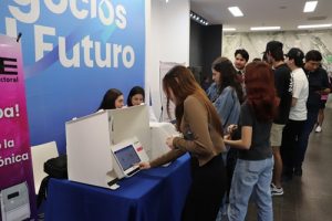 una persona emitiendo su voto en urna electrónica