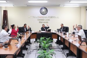 miembros del consejo local votando con mano alzada