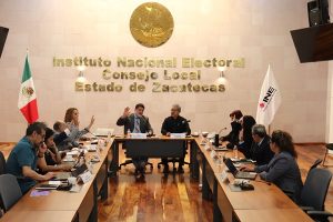integrantes de consejo local sentados y votando a mano alzada