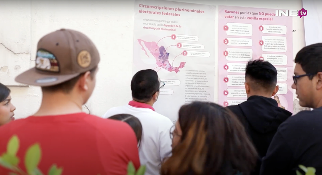 Personas viendo mapas electorales