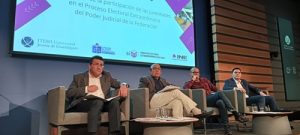 tres personas sentadas en el presidium