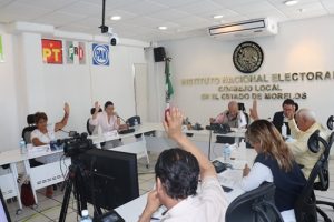 Personas del consejo local votando a mano alzada