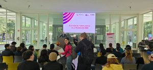 personas sentadas en sillas en foro informativo