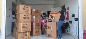 varias personas apilando cajas de carton con material