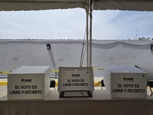 tres diferentes mamparas de votación sobre una mesa