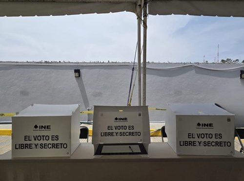 tres diferentes mamparas de votación sobre una mesa